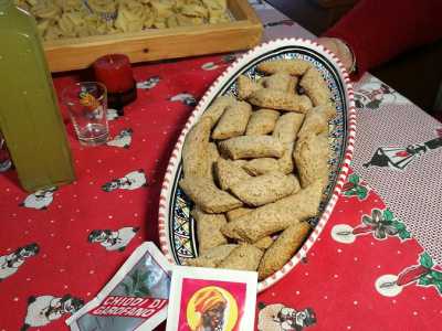 Le castagnelle, che Teresa ha gi� preparato e posato su un piatto di ceramica situato accanto a una bottiglia di limoncello fatto in casa